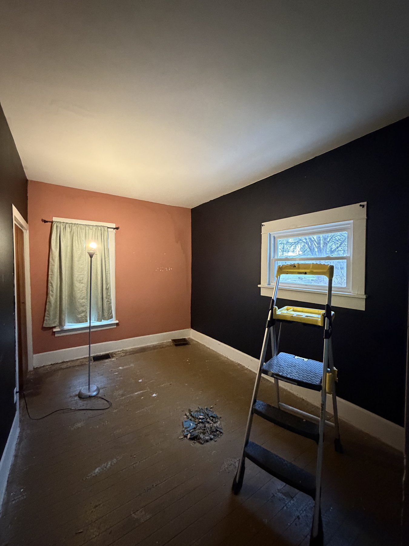 Interior room with dark accent walls and painting equipment