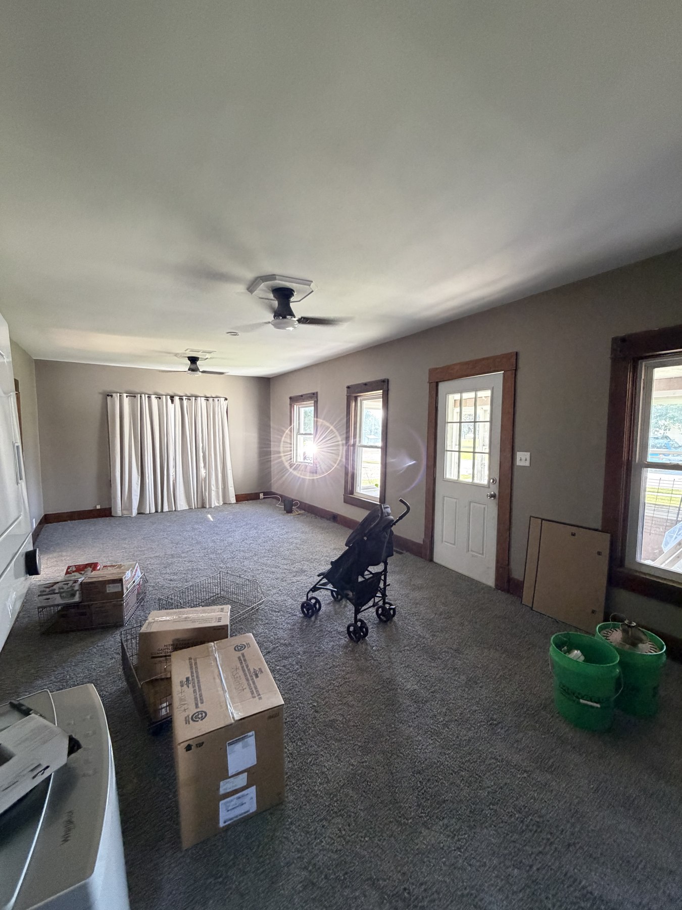 Living room with light-colored walls, window trim, and project supplies